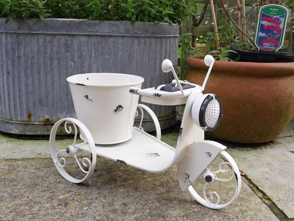 Tricycle shape metal planter with light up solar headlight, distressed white finish